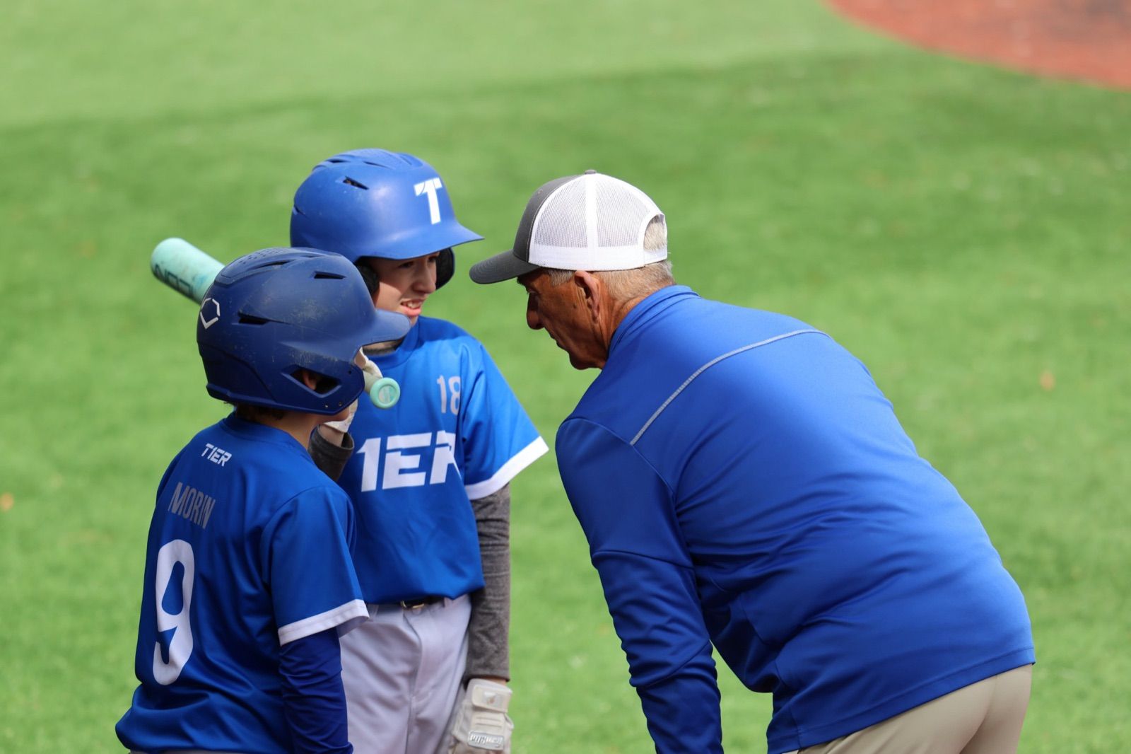 A Tier 1 coach talking with two young players